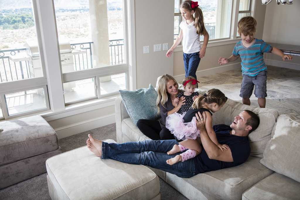 Happy Mixed Race Couple Relax On Couch In Living Room Watch Movie