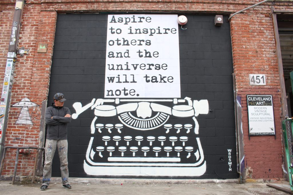 Anonymous Street Artist WRDSMTH in front of one of his works in DTLA