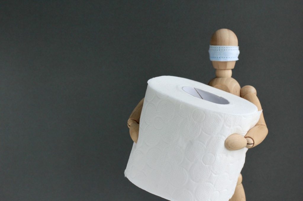 toilet roll in the hands of a wooden doll or mannequin in a medical mask concept of lack of toilet t20 YEGRy0